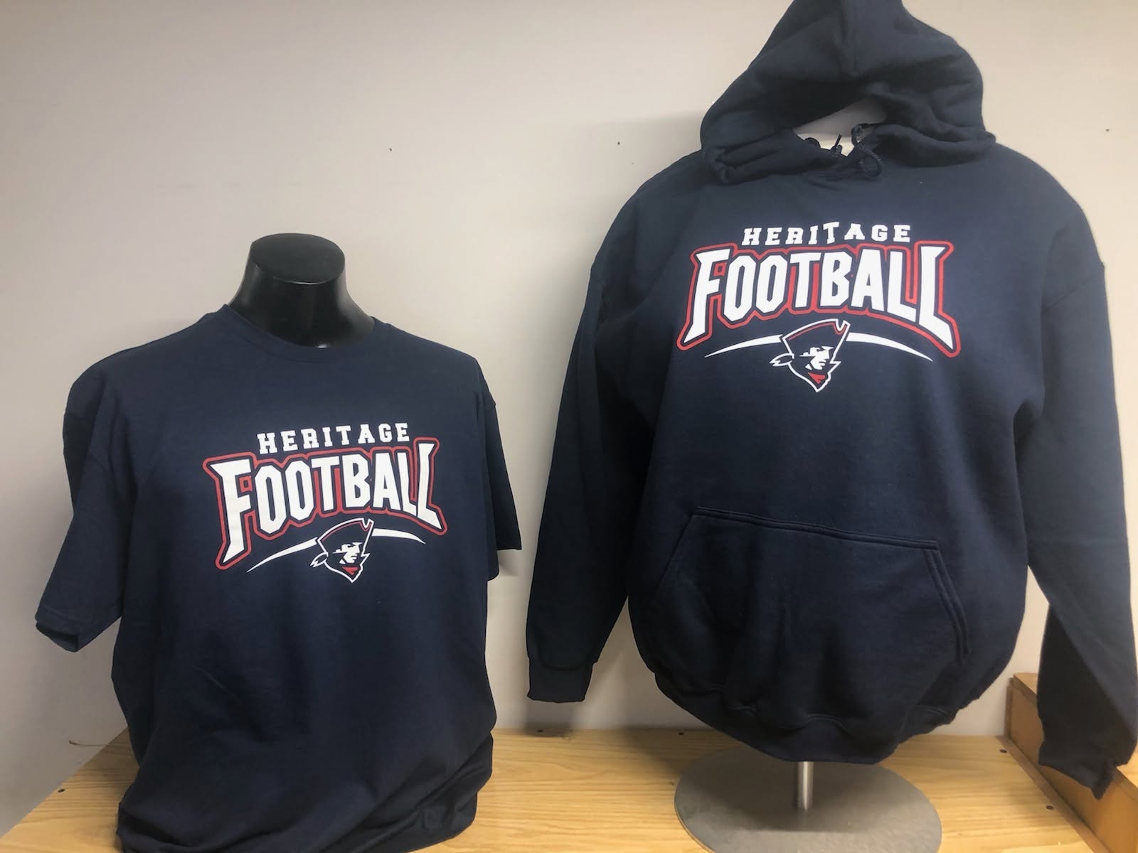 Custom-printed Heritage Football tee and hoodie on display at New Haven Trophies & Shirts