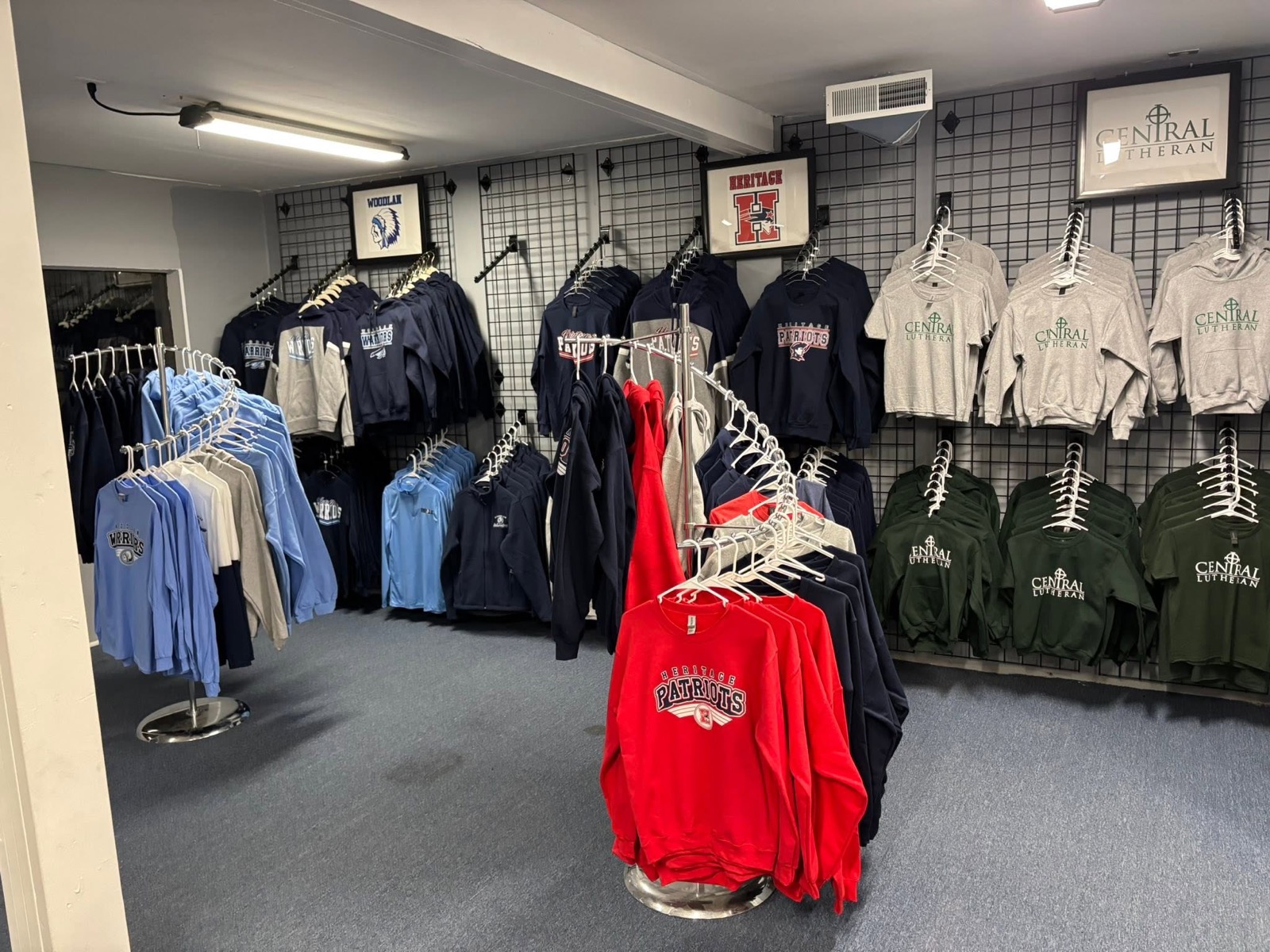 Racks of school spirit wear hoodies and tees inside New Haven Trophies & Shirts